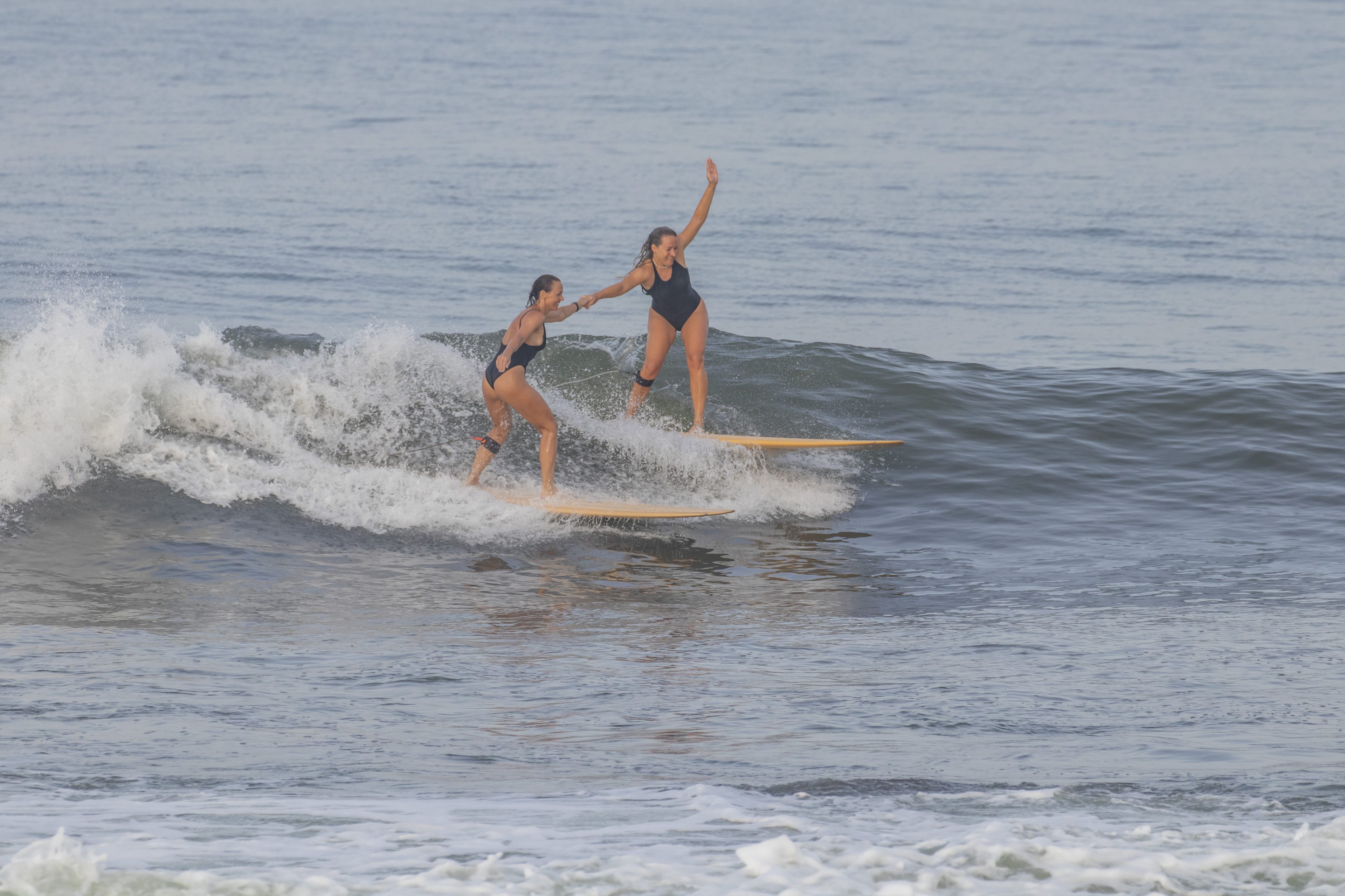 Two surfers sharing a wave at Medewi