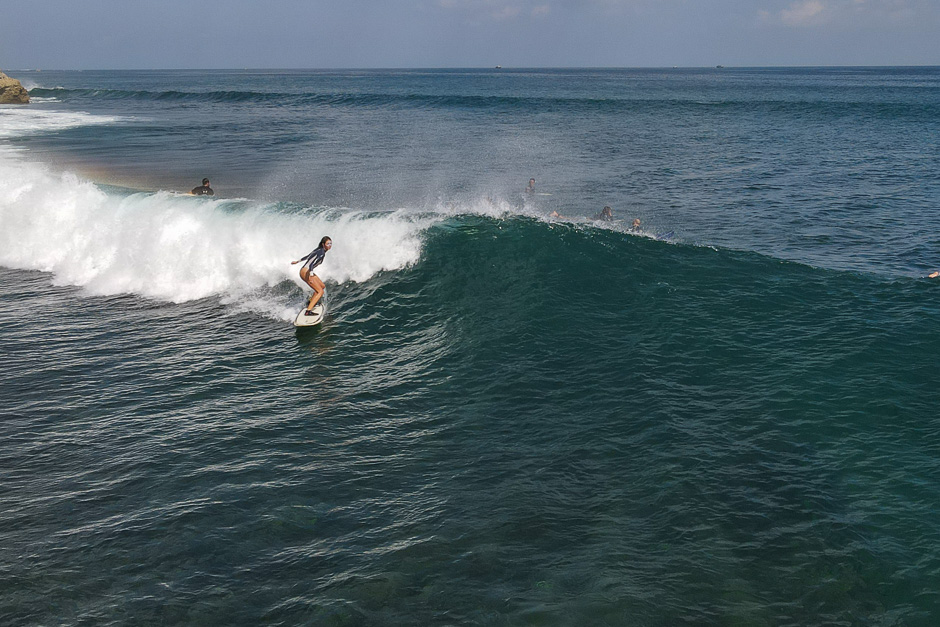 Drone shot of an intermediate surfer riding a wave at balangan.