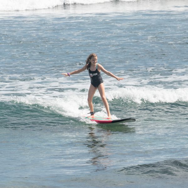 A girl surfing at Padang Padang