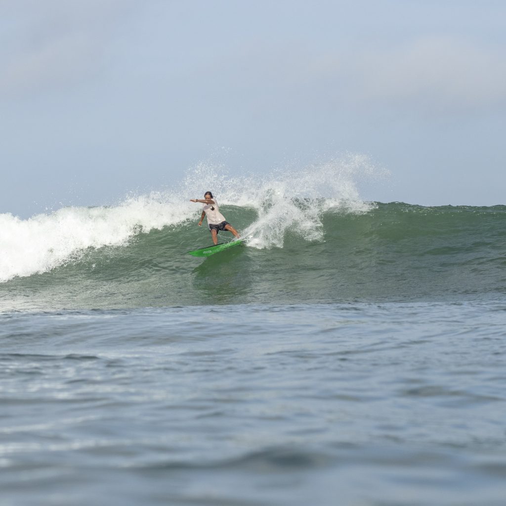 Surfer riding a wave at Kuta Reef.
