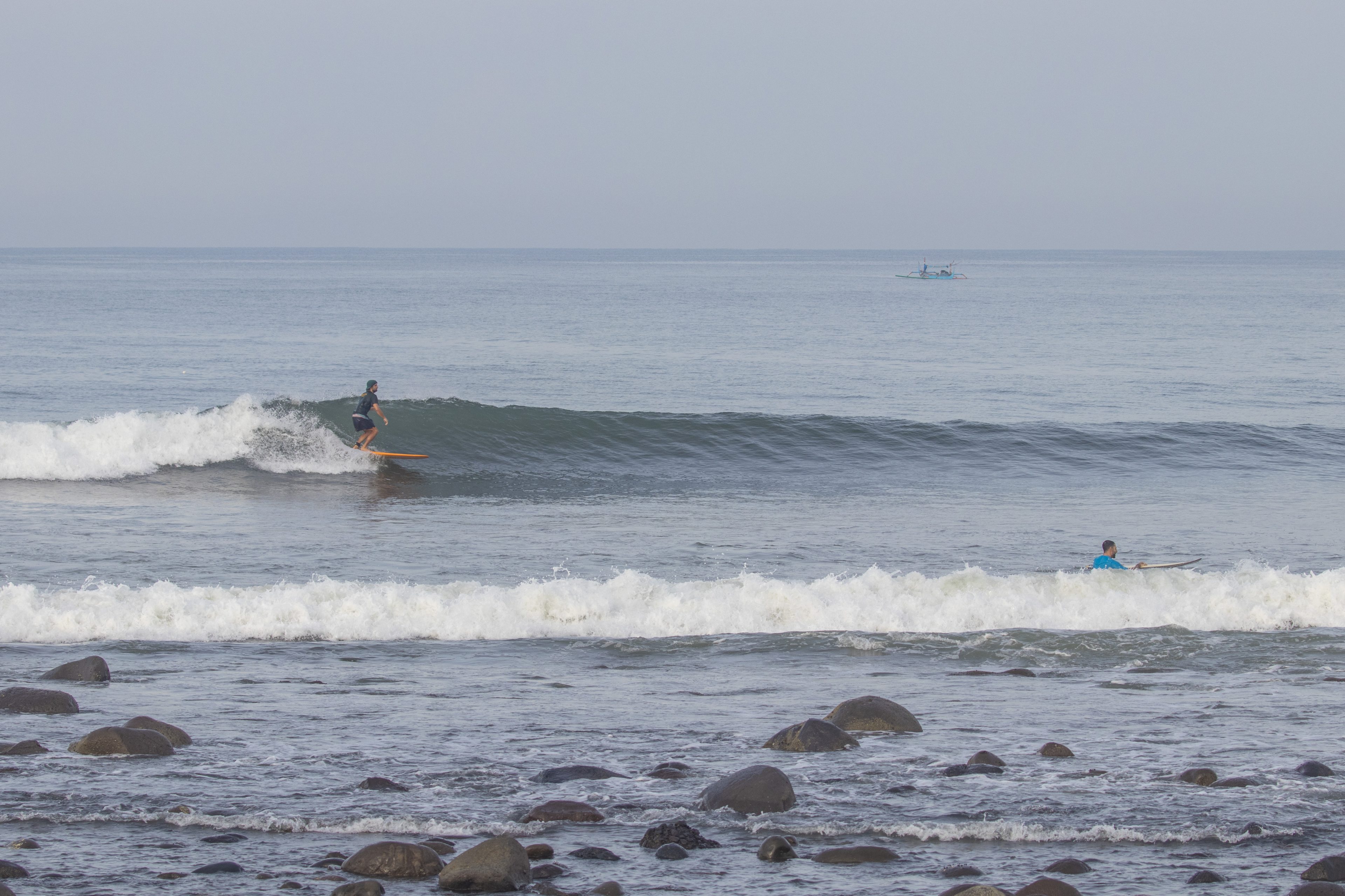 A surfer riding a wave at Medewi.
