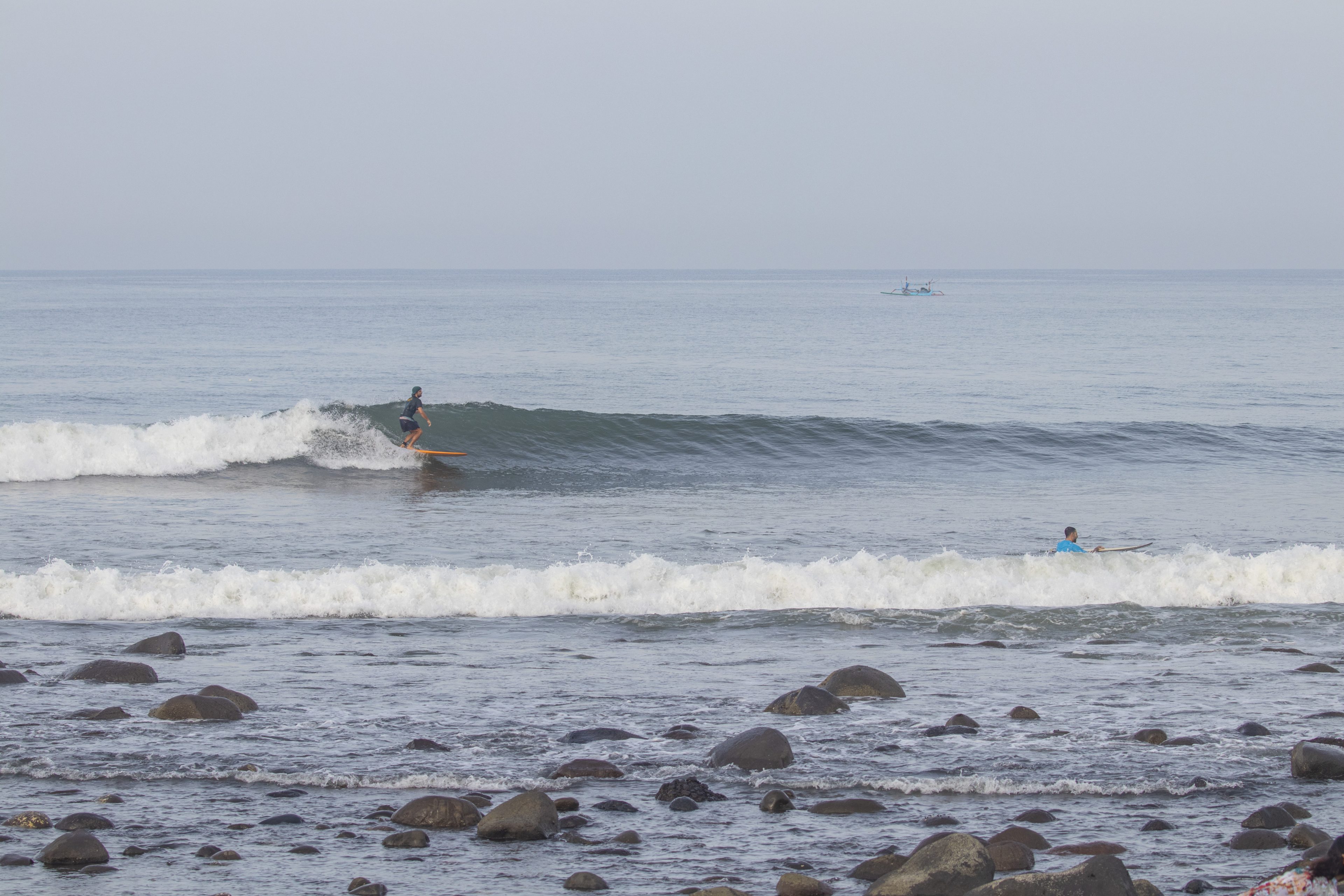 Surfer riding a wave at Medewi.