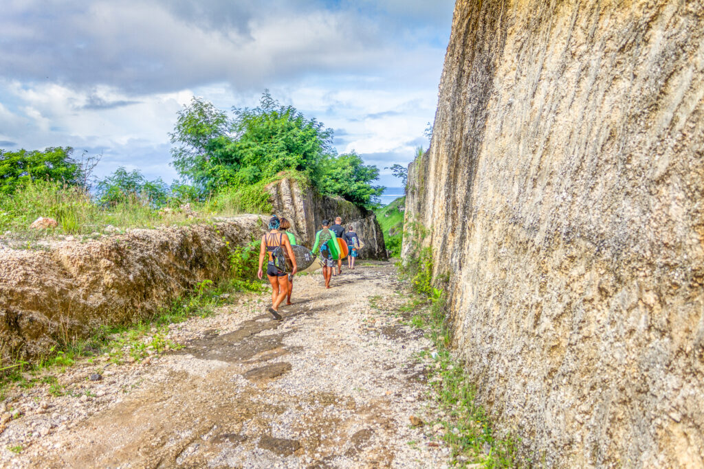 Surfers walking down the path to the beach at Gunung Payung.
