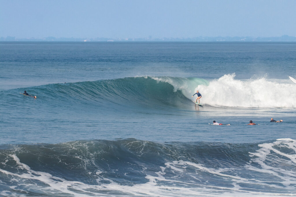 Surfer riding a powerful wave at Klotok.