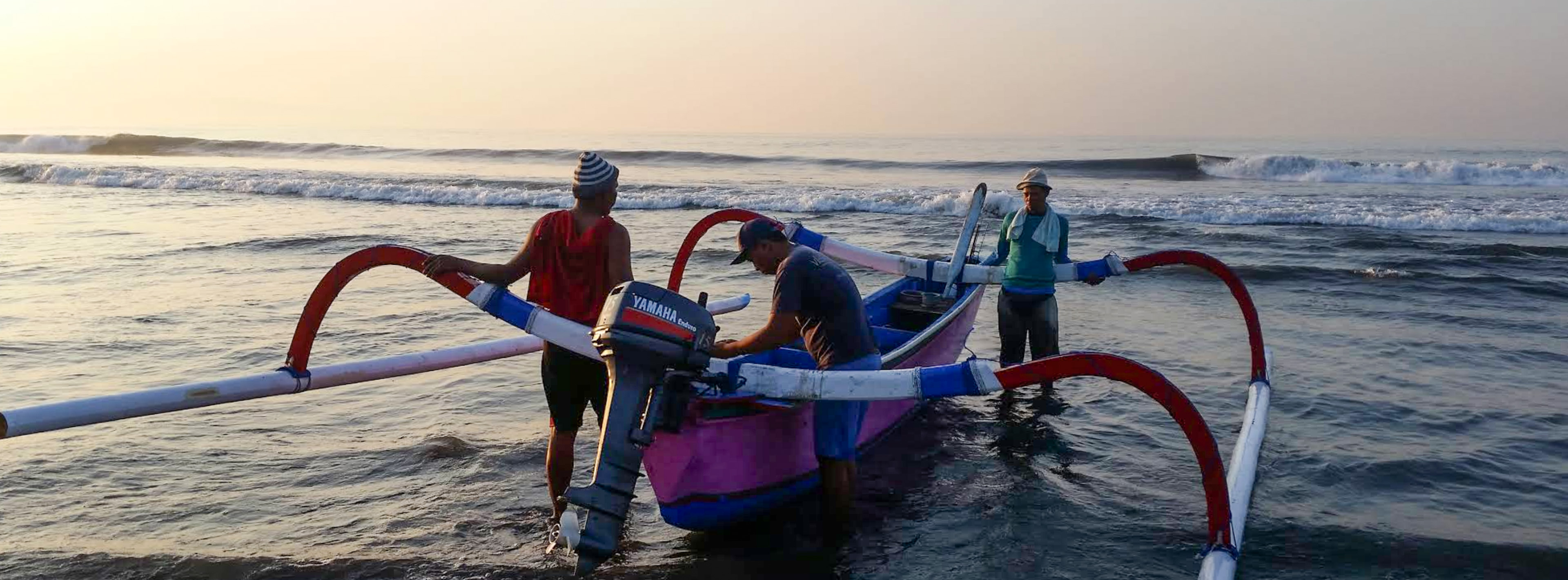 Fisherman taking a boat out at Pantai Gumicik.