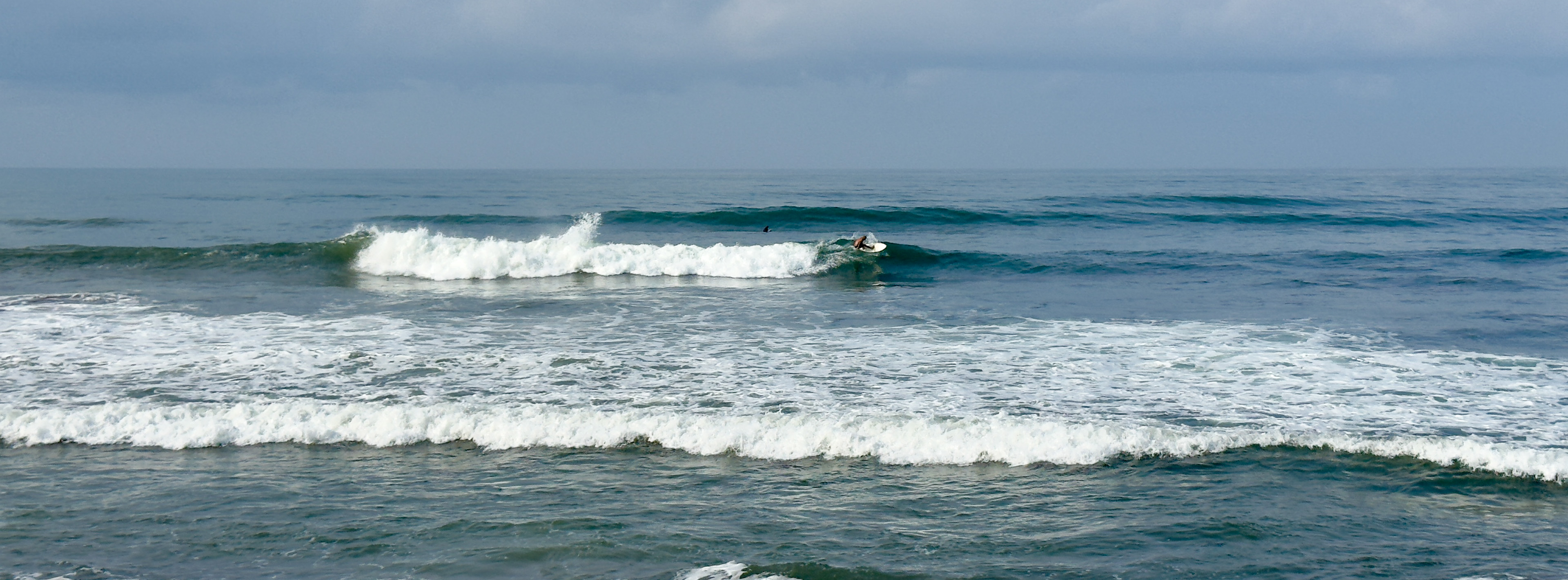 Surfer riding a wave at Pig Stone.