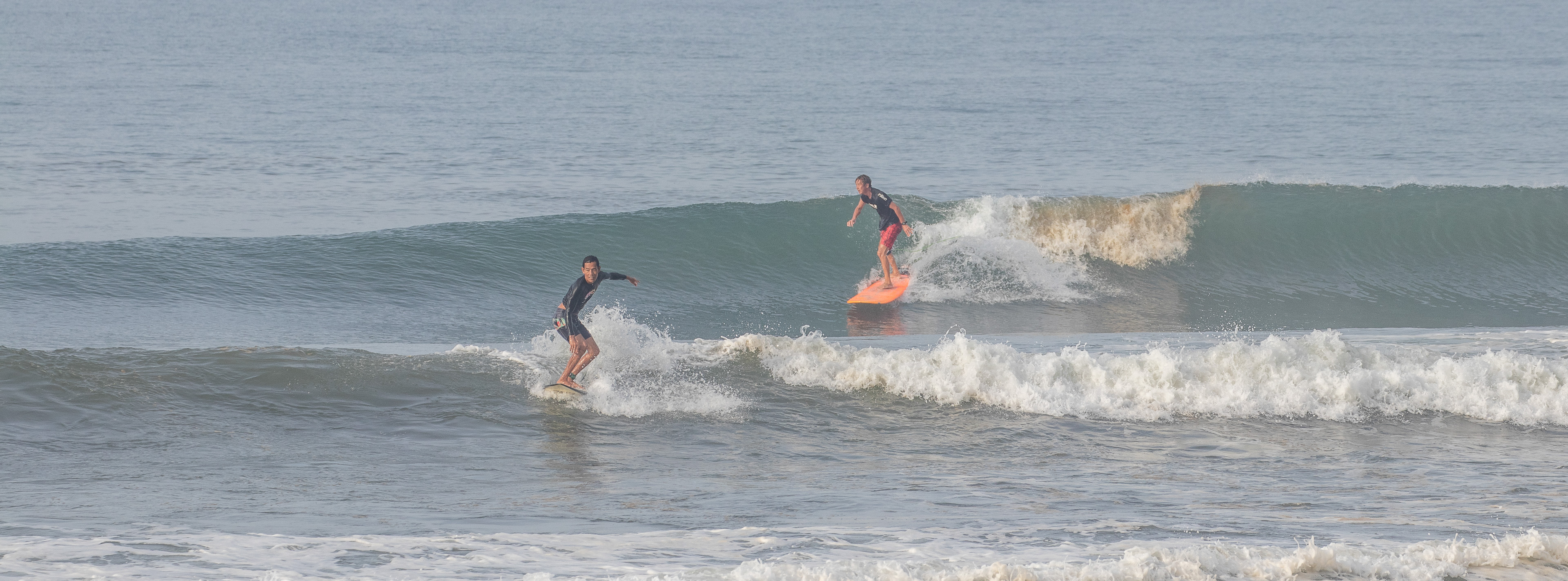 Surfers riding a wave at Yeh Sumbul.